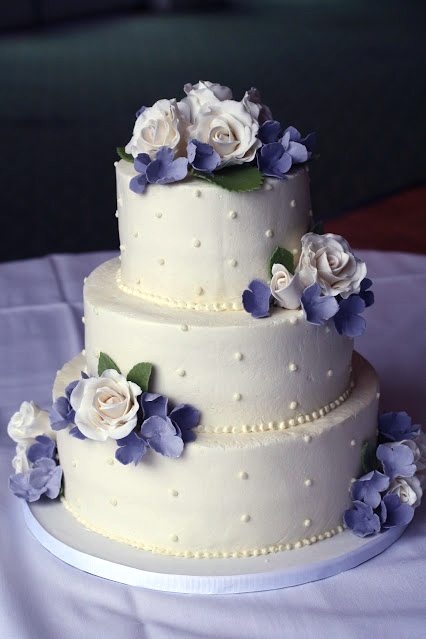blue and white gumpaste flowers wedding cake with swiss dots on buttercream