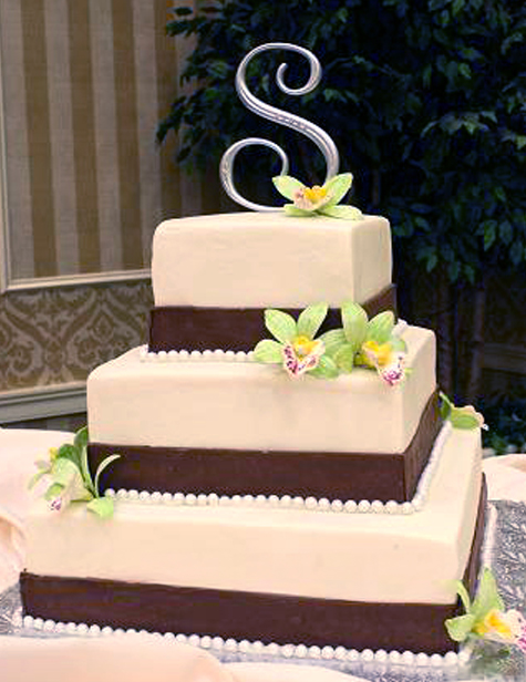 chocolate bands on white square tiers with green gumpaste orchids