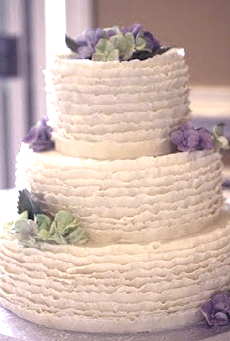 fondant ruffle wedding cake with purple and green gumpaste flowers