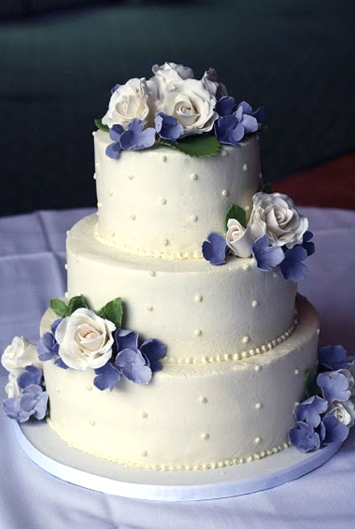 swiss dots wedding cake with grey and blue gumpaste hydrangeas and white roses