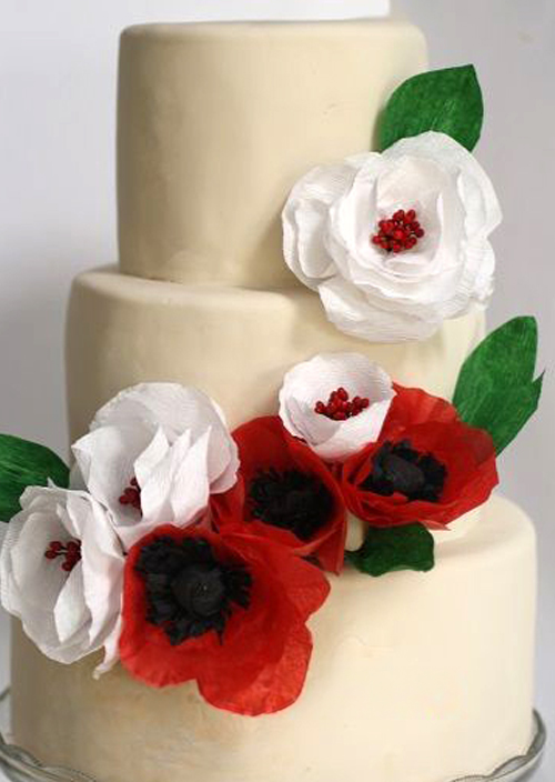 white and red paper flowers on a wedding cake