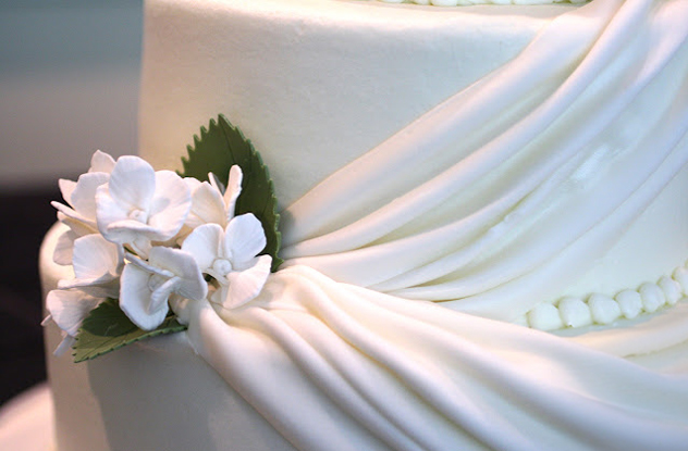 white drape cake with white gumpaste hydrangeas