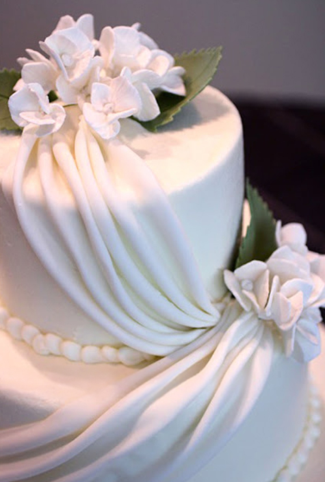 white fondant draping cake with purple gumpaste hydrangeas detail
