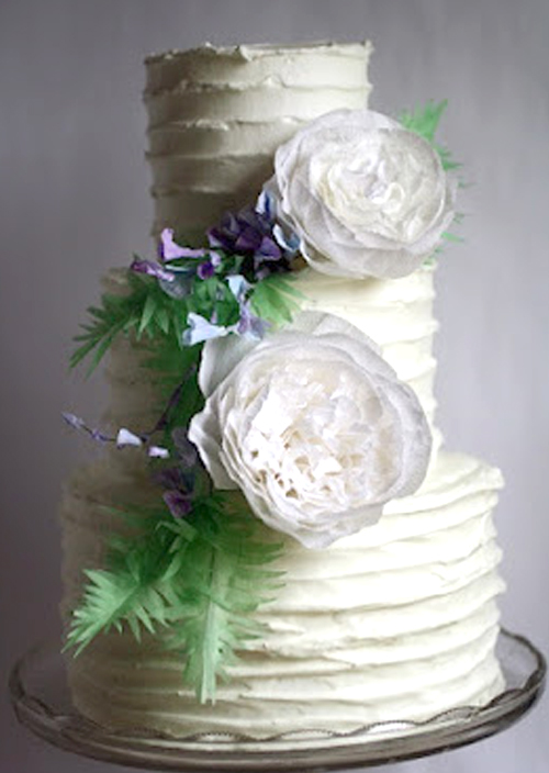 white paper flowers on a rustic wedding cake