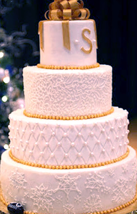 white piped snowflake cake with gold details ad ribbon topper