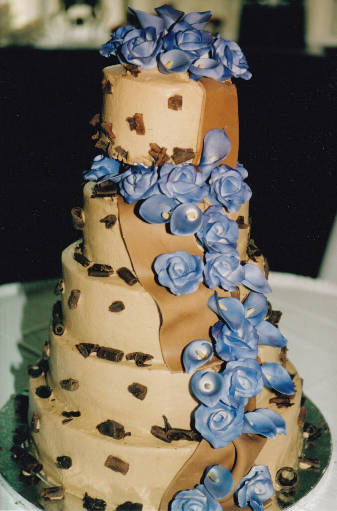 chocolate wedding cake with chocolate ribbon and purple gumpaste flowers