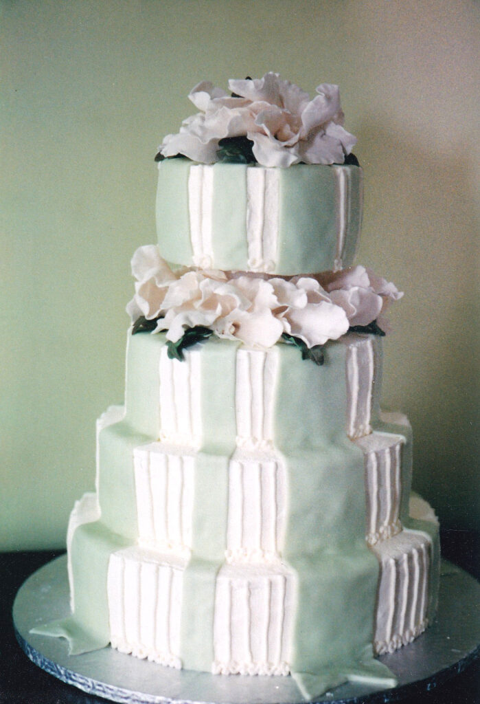 green fondant bows and white gumpaste orchids wedding cake