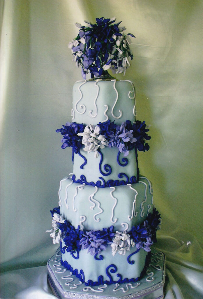 hexagonal purple wedding cake with royal icing piped wisteria flowers