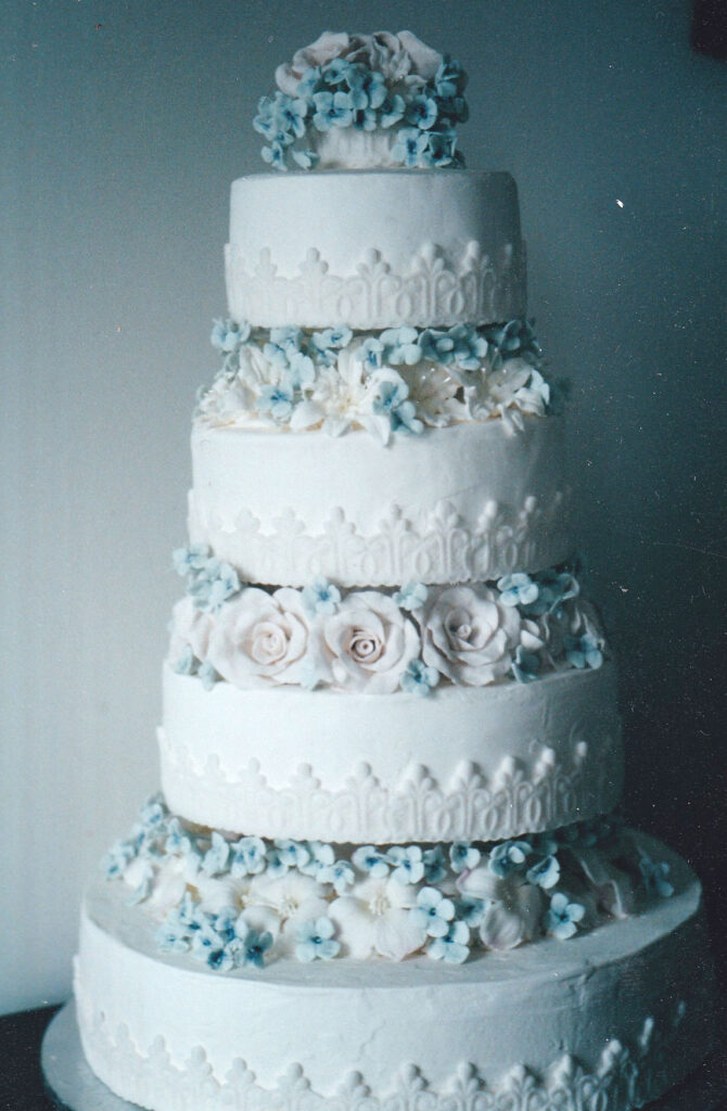 lace wrap border wedding cake with gumpaste flowers between the tiers
