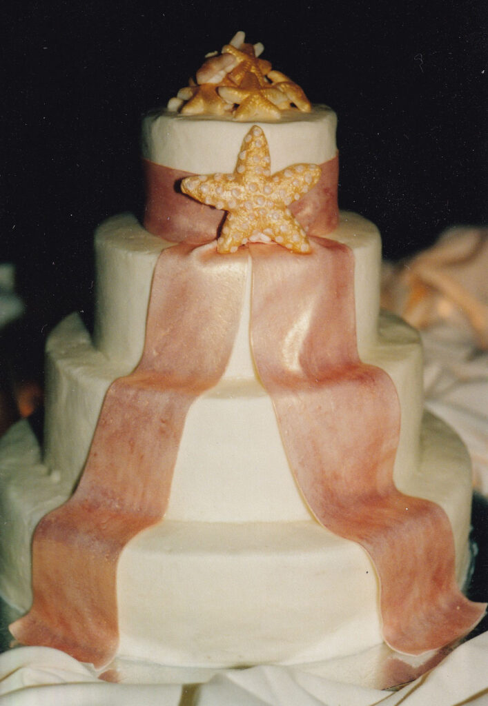 peach ribbon drape wedding cake with gumpaste starfish