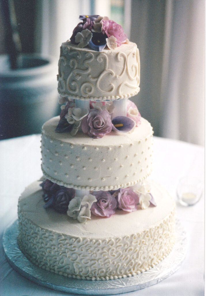 pearls and swirls wedding cake with pillars between all tiers and gumpaste flowers