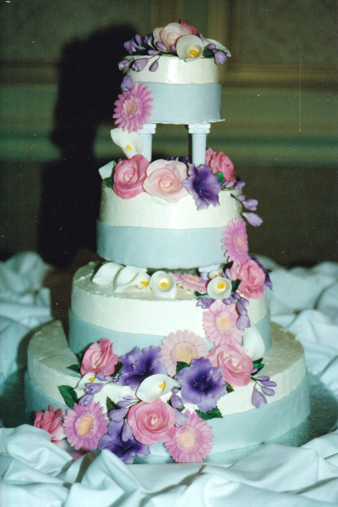 pillars wedding cake with blue bands and spring themed gumpaste flowers