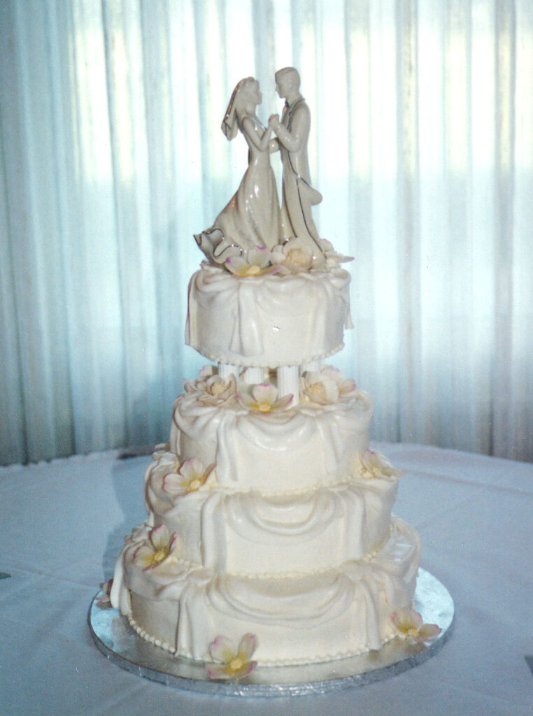 pillars wedding cake with fondant draping and ivory flowers