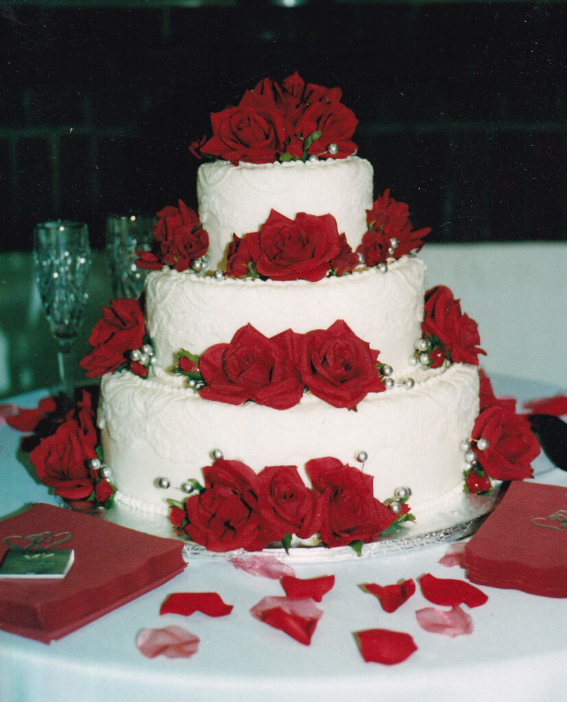 red silk roses on a white wedding cake