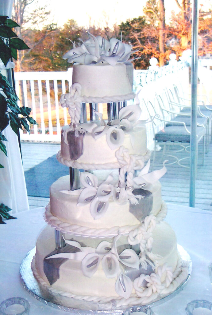 tall silver and white wedding cake with pillars