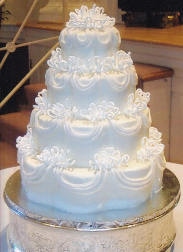white loopy drapes and bows wedding cake