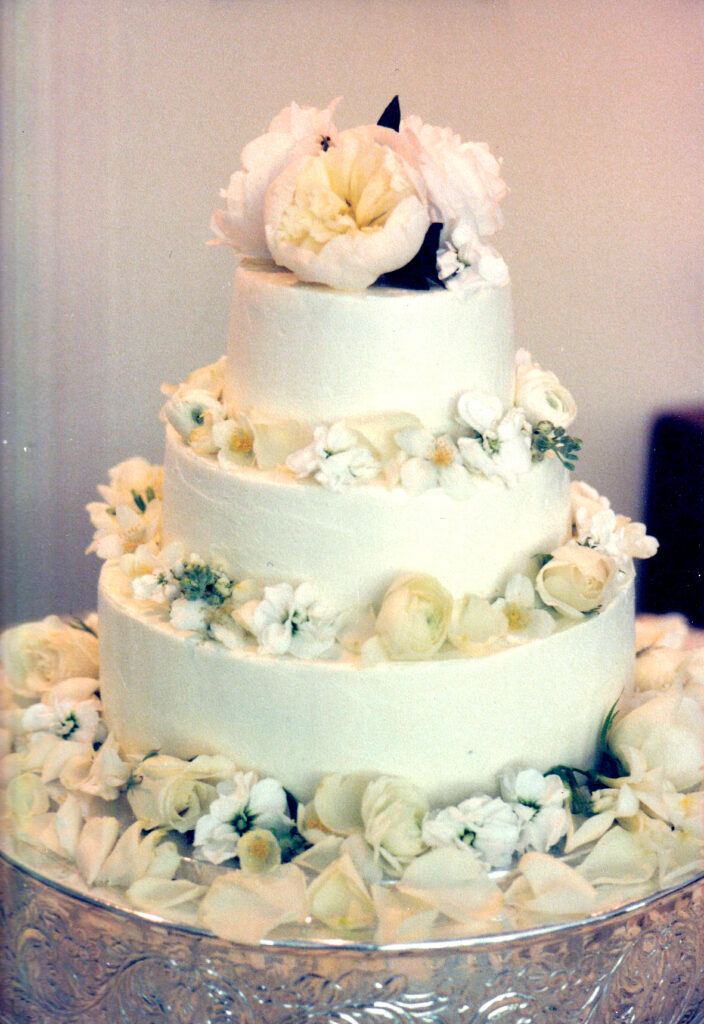 white plain tiered wedding cake with fresh peonies