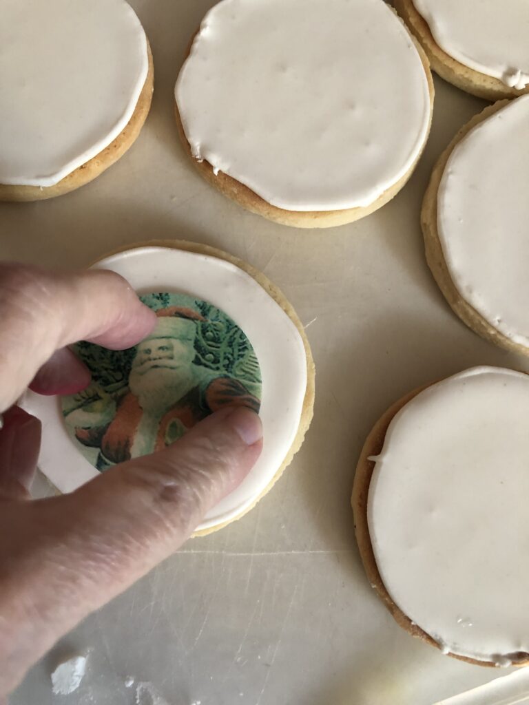 pressing a wafer paper image onto a royal iced cookie