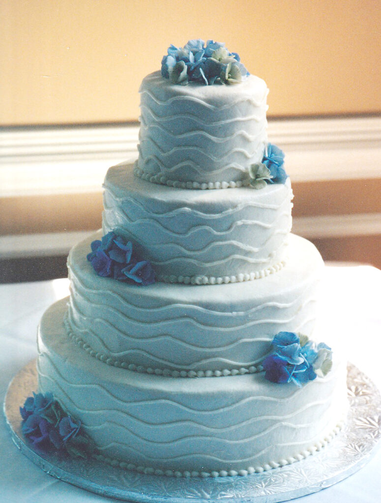 wedding cake with piped lines and gumpaste hydrangeas