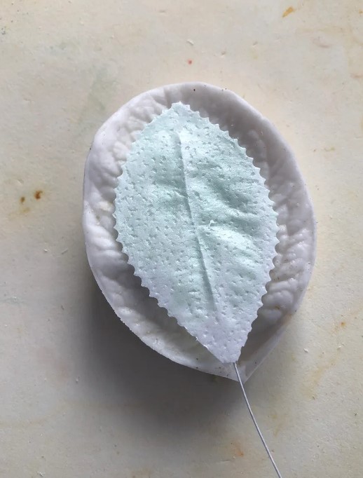 Put the conditioned and veined leaf in a rose petal or other flower petal veiner.
