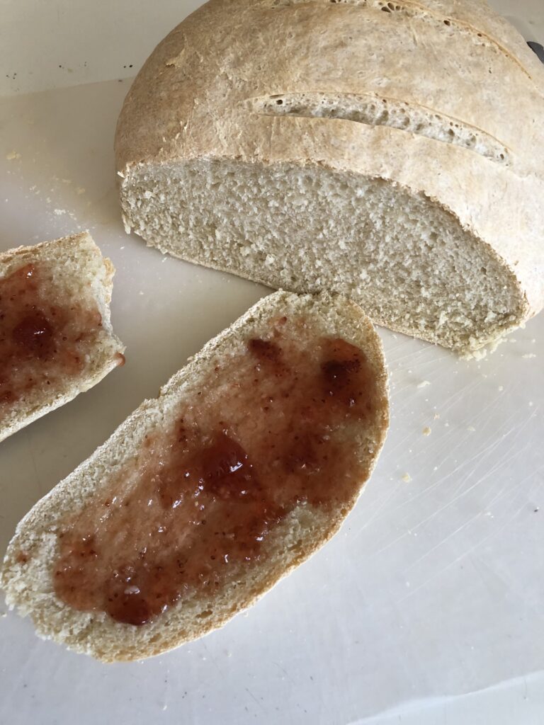 The baked bread cut and with jam on a piece