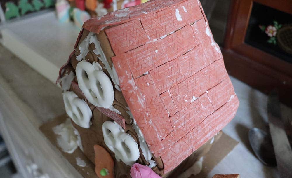 gingerbread house with red gum sticks on the roof