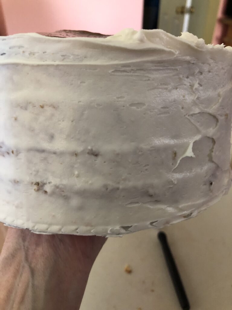 Adding a crumb coat of icing to the cake